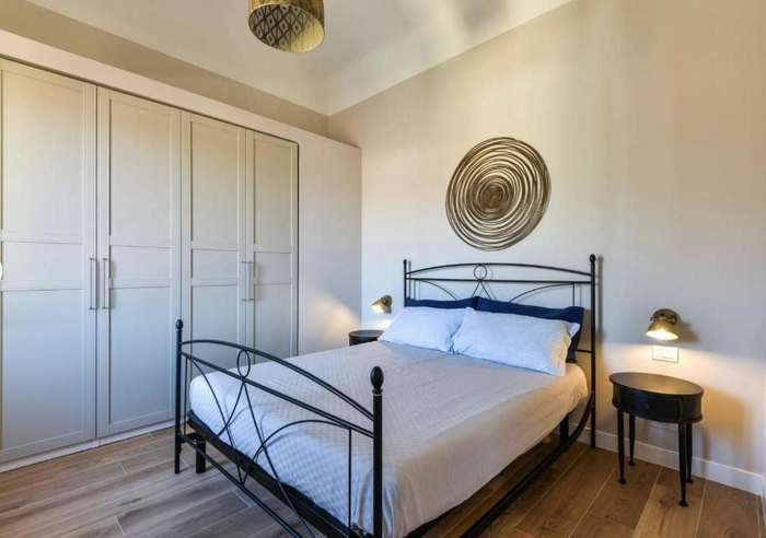 Camera con letto matrimoniale in ferro battuto e armadio a muro