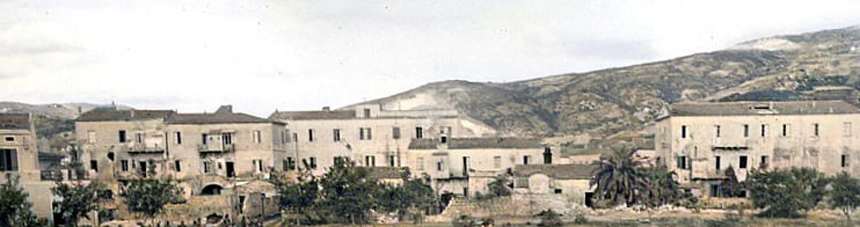 Il fronte del paese di Marina di Campo nel 1943–45, con le case basse e la collina sullo sfondo