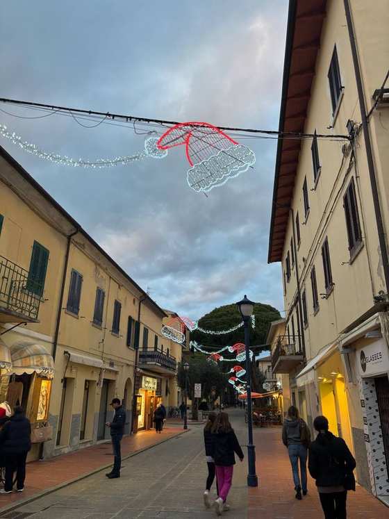 Gente a passeggio in una via del centro con le luminarie natalizie