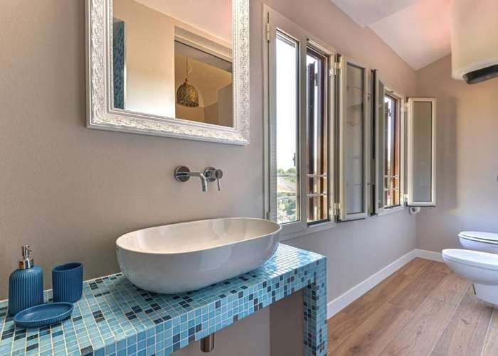 Lavabo su piano in mosaico azzurro, con finestre