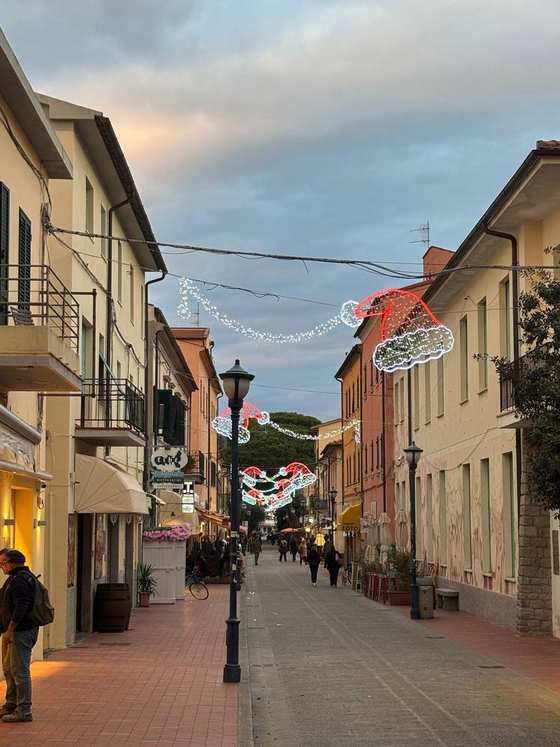 Una via del centro con le luminarie a forma di cappello di Babbo Natale